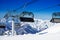 Chairs on chairlift ropeway in winter mountains