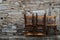 Chairs piled up outside an old stone wall