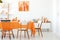 Chairs at table in white and orange dining room