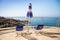 Chairs and umbrella on balcony overlooking ocean and rocks