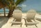 Chaise lounge chairs on a tropical beach.