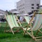 Chaise lounges on a lawn. Garden sunbeds on green grass