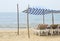 Chaise lounges under a canopy on the beach near the ocean