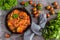 Chakhokhbili, chicken stew, cooked with tomatoes, bell peppers, spices and herbs. Dark wooden background, top view