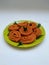 Chakli in a Green Plate  on White Background. Indian Snack Chakli or chakali made from deep frying portions of a lentil