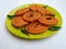 Chakli in a Green Plate  on White Background. Indian Snack Chakli or chakali made from deep frying portions of a lentil