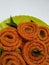 Chakli in a Green Plate  on White Background. Indian Snack Chakli or chakali made from deep frying portions of a lentil