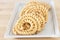 Chakli or Murukku popular vegetarian snack South India. Spiral shaped crisp deep-fried snack. Close up.. Selective focus.