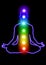 chakras.  man meditating with glowing chakras black background