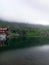 Chalet reflecting in glacier lake on cloudy day