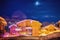 Chalet wooden houses covered with heavy snow in Val Thorens in the evening with moon and stars in the sky