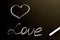 A chalk board with the word love and a heart. Grunge background texture