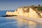 Chalk cliffs at Cote d`Albatre rocks and natural arch landmark and blue ocean in Etretat. Normandy France