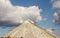 Chalk mountains against a cloudy blue sky in a green field in Ukraine