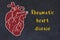 Chalk sketch of human heart on black desc and inscription Rheumatic heart disease