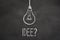 Chalk text `Idee` and lightbulb on chalkboard. Translation: `Idea`