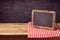 Chalkboard background with red checked tablecloth over black brick wall