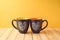 Chalkboard coffee mugs with heart shape on wooden table. Friendship day concept