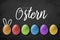 Chalkboard with easter eggs and the german word for happy easter - frohe Ostern