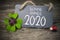Chalkboard with four leaf clover and chimney sweeper and sparklers with bonne annee 2020 on wooden background