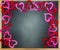 Chalkboard framed by red and pink felt cutout hearts, space