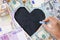 Chalkboard with heart shape from cash us dollars and euro banknotes with copy space to insert text