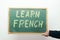 Chalkboard with LEARN FRENCH handwritten in chalk