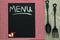 Chalkboard menu sign on red checkered tablecloth with cast iron spoon and fork