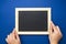 Chalkboard mock up. Female hands holding blackboard on a blue background, isolated. Copy space, flat lay. Business, education