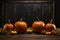 Chalkboard stand, pumpkins on wooden floor, set against intense black backdrop