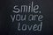 Chalkboard text `smile you are loved`