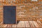 Chalkboard wood frame, blackboard sign menu on wooden table and brick wall background.