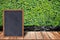 Chalkboard wood frame, blackboard sign menu on wooden table and grass wall background.