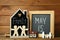 Chalkboards, family figures and toys on wooden background