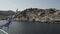 Chalki / Halki island, Greece - September 25, 2020: People in mask on ship looking at the island with ceramic-tiled roofs