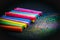 Chalks in a variety of colors on black background.