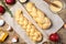 Challah bread before baking. Proofing sweet buns sprinkled with sesame seeds on parchment. Pomegranate, egg shells and butter for