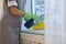 Chambermaid cleaning window sill with rag indoors, closeup