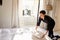 Chambermaid placing fresh linen on to a bed in a hotel room