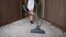 Chambermaid vacuuming in hotel corridor
