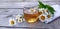 Chamomile aromatic tea in a glass cup on a wooden background. Summer still life with wildflowers and medicinal herbal drink.