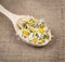Chamomile flowers on a wooden spoon