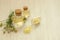Chamomile water hydrolate in glass bottles, yellow bath salt and fresh flowers on white wooden table background