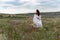 Chamomile woman. Happy curly woman in a chamomile field, dressed in a white dress.