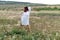 Chamomile woman. Happy curly woman in a chamomile field, dressed in a white dress.