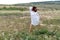 Chamomile woman. Happy curly woman in a chamomile field, dressed in a white dress.