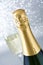 Champagne bottle with glass cup on brilliant silver background