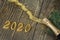 Champagne bottle with golden tinsel, ribbon and confetti on a dark wooden background. Golden bow, Christmas tree branch