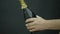 Champagne explosion. Man hand opening champagne bottle closeup. Sparkling Wine over Holiday Bokeh Blinking Background