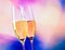 Champagne flutes with golden bubbles on blur decorative hearts background